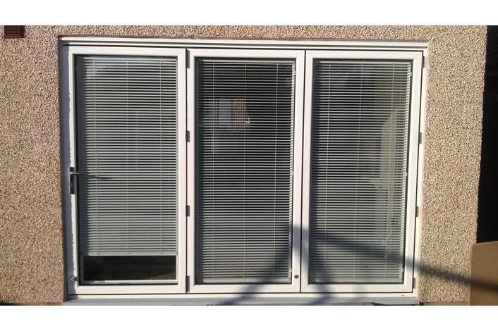 White Visofold 1000 folding door fitted with blinds.