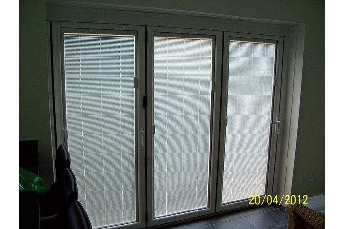 White upvc folding doors with integral blinds fitted.