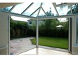 Convervatory featuring white-framed bi-folds - looking out to the garden area.